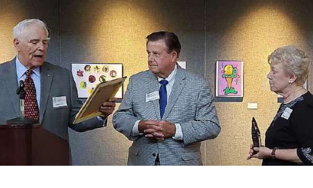 Wayne Rickman reads to award plaque presented to Harriet Haynes while David Tavernier looks on
